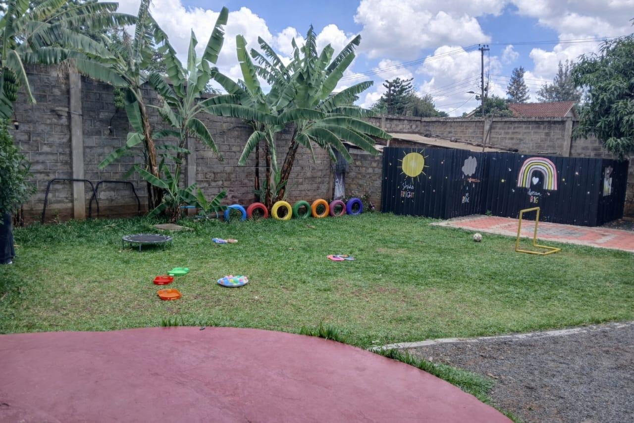 Colourful playground with tires, trampoline and goal post