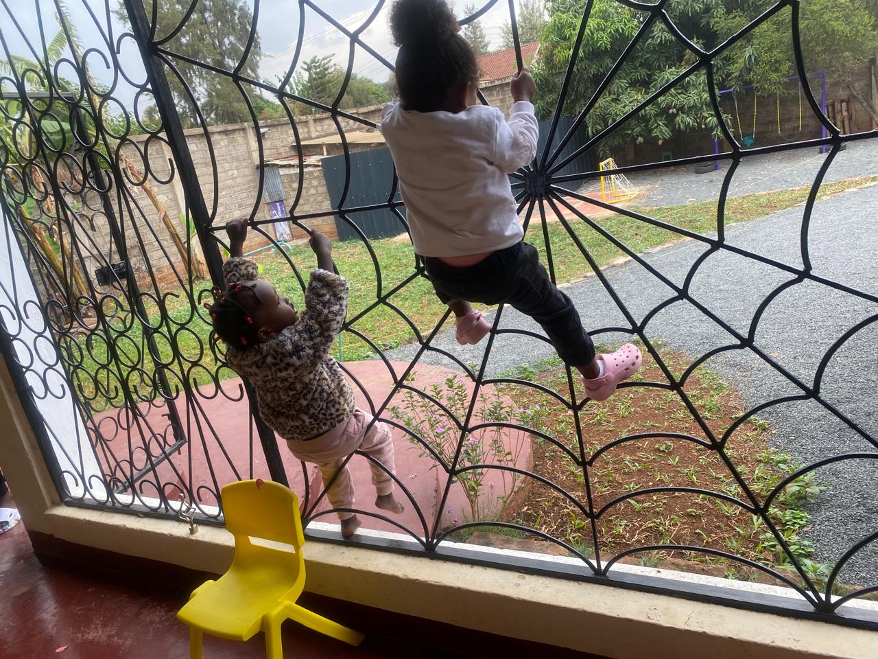 Children playing on the spider-web climbing structure