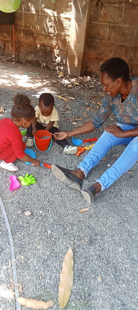 Teacher Sheila, School Principal, playing with children outdoors