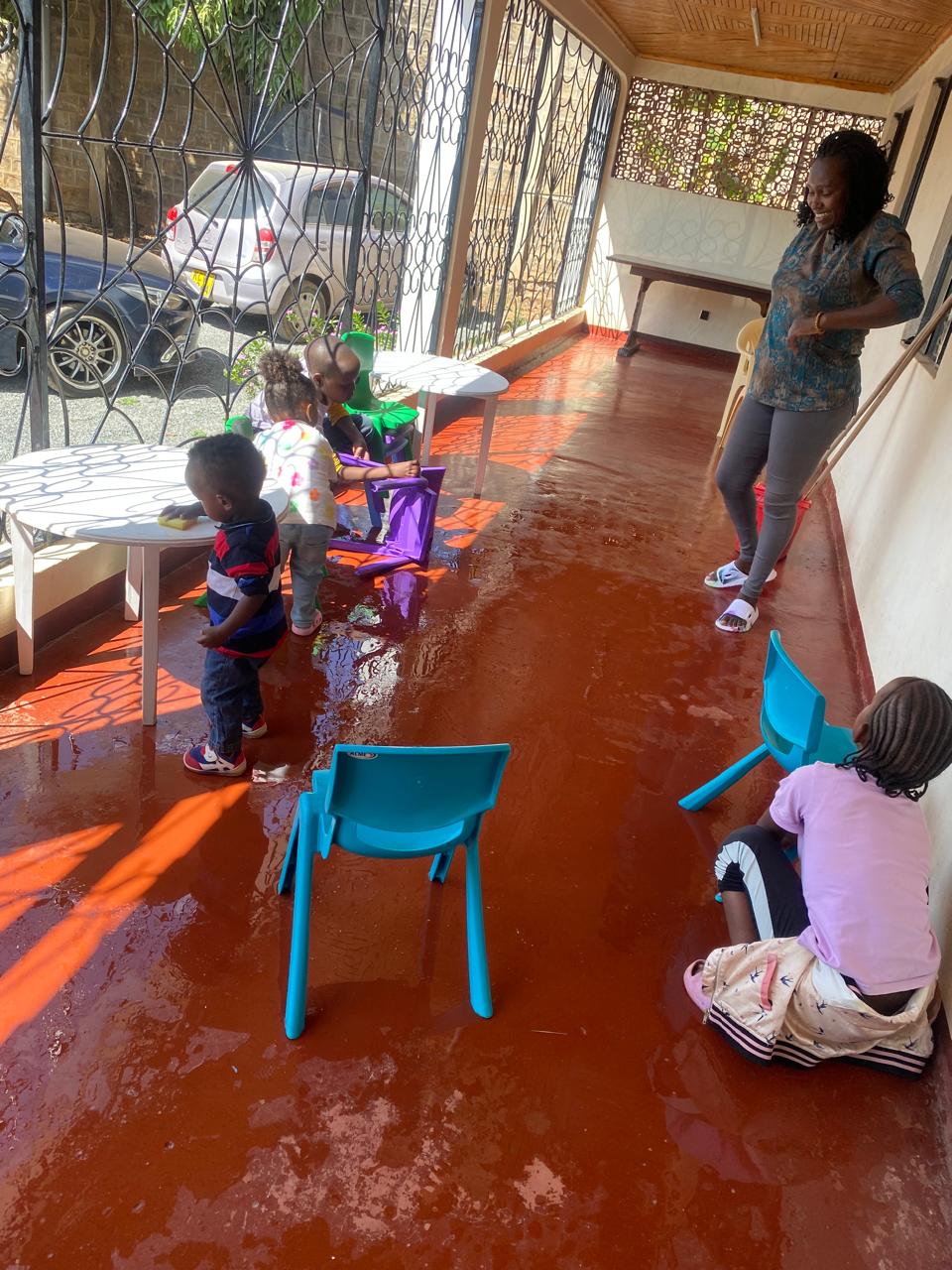 Teacher nurturing young children in the classroom verandah